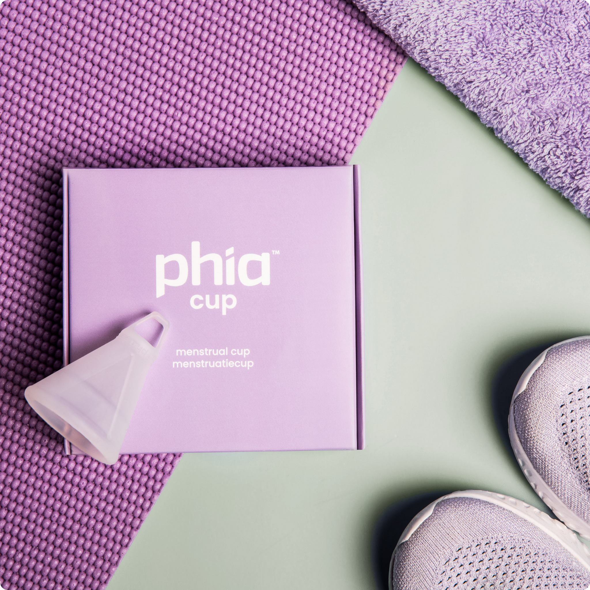 Phia Menstrual Cup while exercising with a yoga mat and running shoes. 