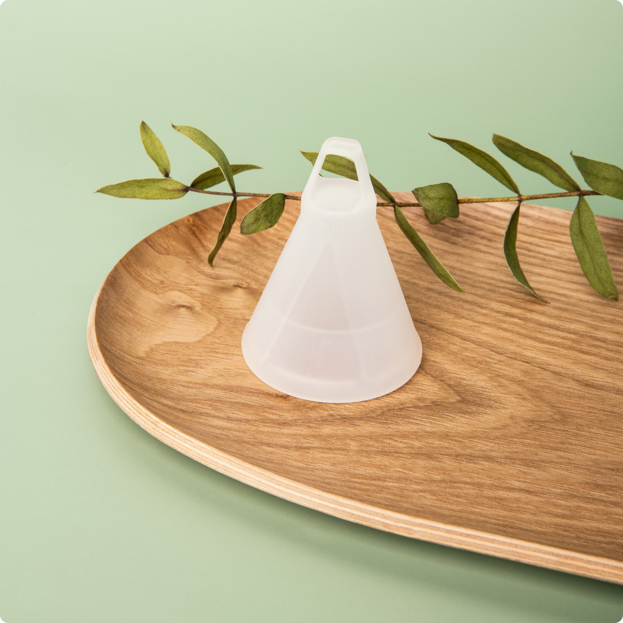 Phia Menstrual Cup on a wooden display